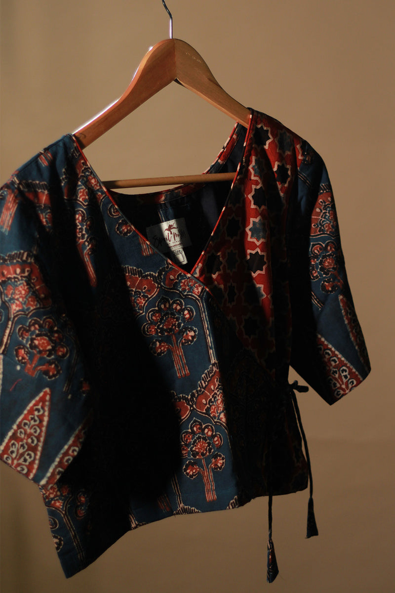 Traditional patterned garment on a hanger against a plain background
