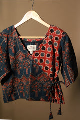 Patterned top on a hanger against a plain background