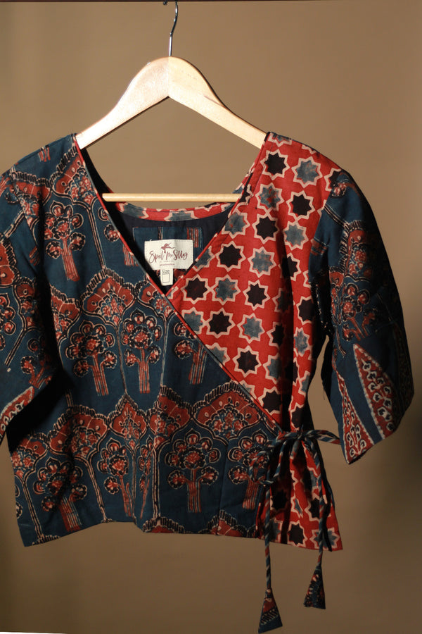 Patterned top on a hanger against a plain background