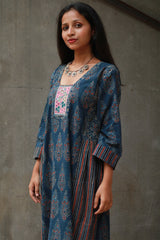 Woman wearing a blue patterned dress with a gray background