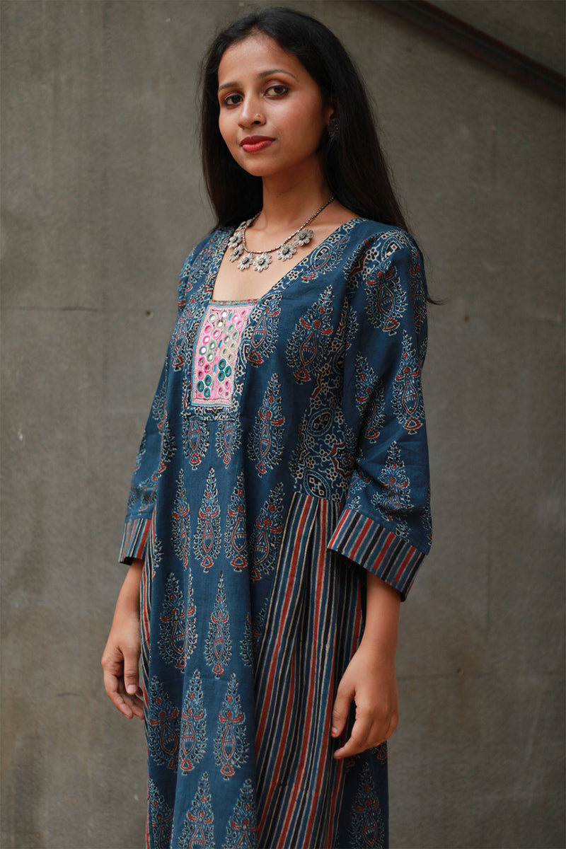Woman wearing a blue patterned dress with a gray background
